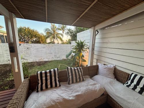 a couch sitting on a porch with pillows on it at Villa Pétrel in Saint-Paul