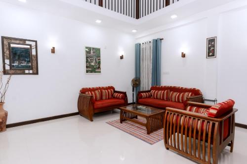 a living room with two red couches and a table at Villa Wings Airport Transit in Andiambalama
