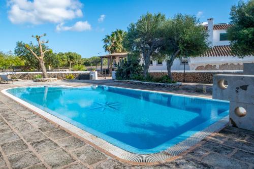 a swimming pool with blue water in a yard at Turismo Rural Biniati des Pi in Sant Lluis
