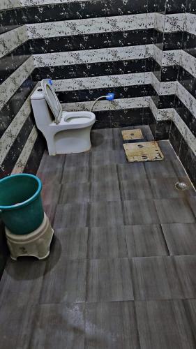 a bathroom with a toilet and a bucket at Shri Swami Ji Dham in Jāmb