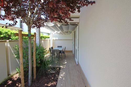 a patio with a table and chairs and a tree at Villetta Simonetta in Cinquale
