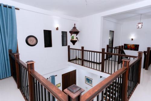 a staircase in a house with a clock on the wall at Villa Wings Airport Transit in Andiambalama