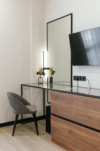 a desk with a television and a chair in a room at Select Hotel in Lviv