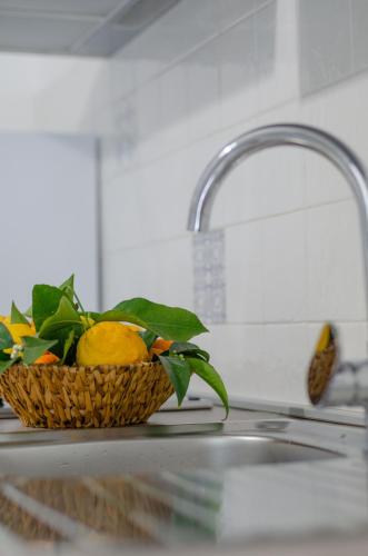 a basket of lemons sitting on a counter next to a sink at Le Case di Chri in Mattinata