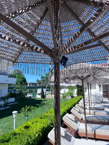 a pergola with chairs and umbrellas on a patio at Residence LEORA in Ulcinj