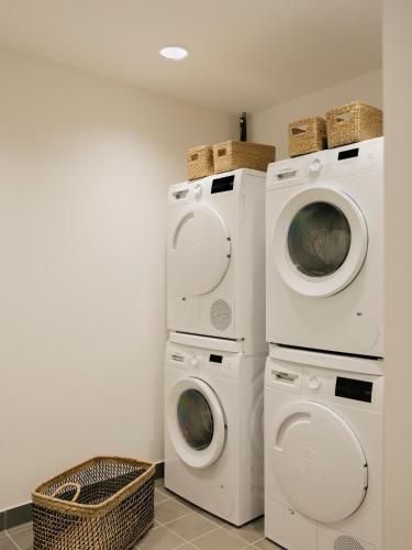 two washing machines and a washer and dryer in a room at Edgar Suites - Église in Paris
