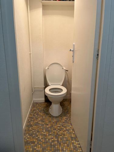 - une salle de bains avec des toilettes blanches dans une cabine dans l'établissement Prométhée - Chambre colocation - Hypercentre Mans, au Mans