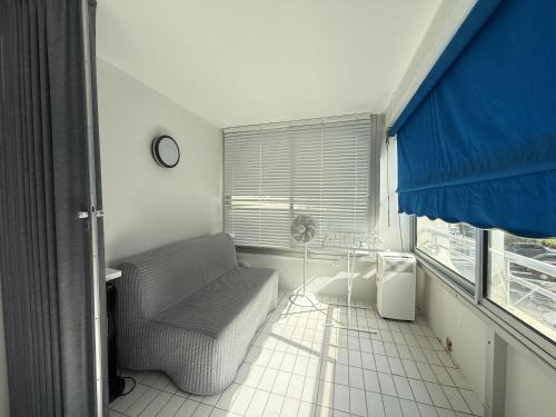 un salon avec un canapé et une fenêtre dans l'établissement Sol-y-Days Arc en ciel, appartement moderne proche plages, à La Grande Motte