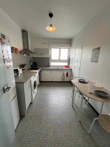 une cuisine avec un réfrigérateur et une table à l'intérieur dans l'établissement Prométhée - Chambre colocation - Hypercentre Mans, au Mans