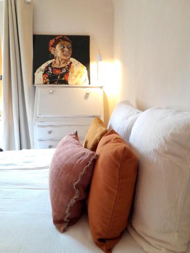 - une chambre avec un lit avec des oreillers et un tableau dans l'établissement Moulin Caro, à Rosnoën