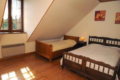 une chambre avec deux lits dans un grenier dans l'établissement Le saint martin, à Saint-Rémy-sous-Barbuise