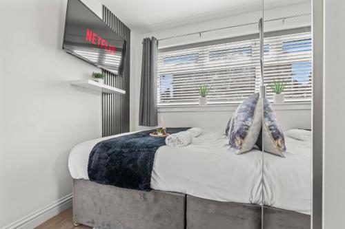 a bedroom with a large bed with a window at La Maisón, City Centre House, EV Parking, Fast WiFi, Netflix Private Entrance, Garden in Coventry