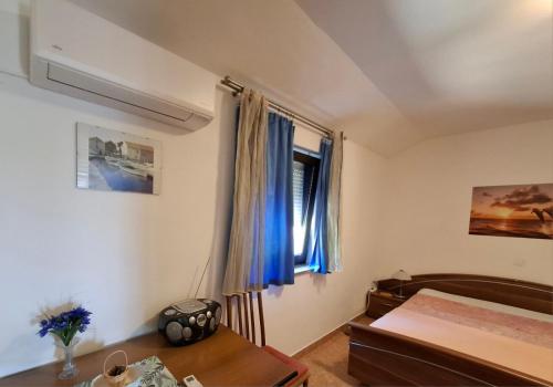 sypialnia z łóżkiem, stołem i oknem w obiekcie Apartment RB w mieście Omišalj