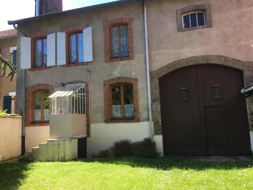 a house with a brown garage door in the yard at Al Onde d Isis in Manheulles