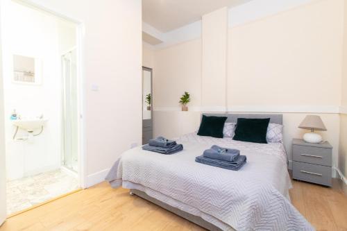 a white bedroom with a bed with towels on it at Thornbury Guest House Room 3 in Southampton