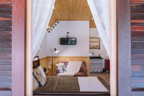 a room with a bed and a tv on the wall at Apartamento Le Deux Avenida in Monte Verde