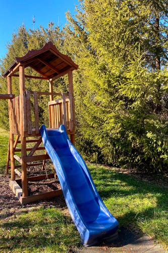 a blue slide next to a wooden playground at Csibi Apartman in Szilvásvárad