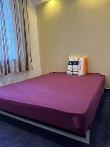 a large purple bed with two pillows on top of it at Hub Property in Góra Kalwaria