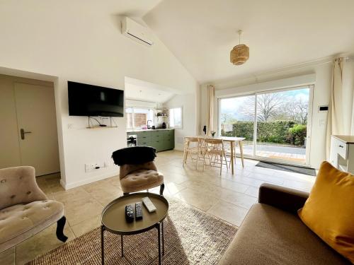 un salon avec un canapé, des chaises et une table dans l'établissement Maison cosy entre océan et montagne, à Hasparren