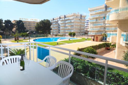 a balcony with a table and chairs and a swimming pool at UHC Larimar Family Complex in Salou