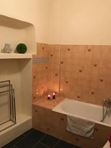 a bathroom with a tub and two candles in it at Petit cocon in Villefranche-sur-Mer