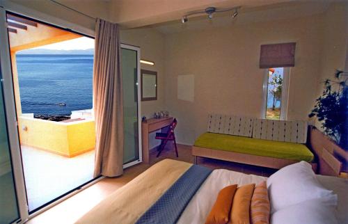 sypialnia z łóżkiem i widokiem na ocean w obiekcie Volissos Holiday Homes w mieście Volissos