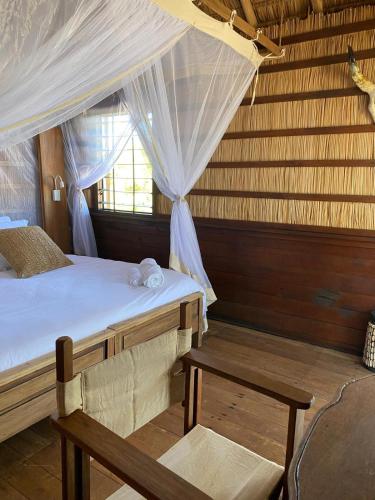 a bedroom with a bed with a canopy and a bench at ENTREMER in Belo