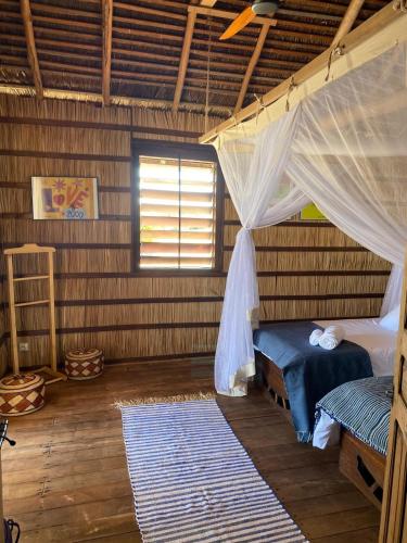 a bedroom with a bed and a mosquito net at ENTREMER in Belo