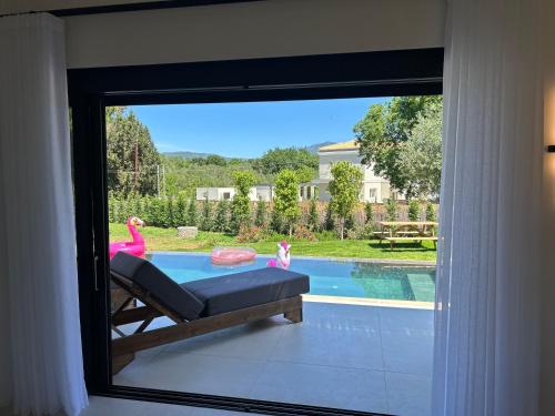 a window with a view of a swimming pool at Villa Danai in Gouvia