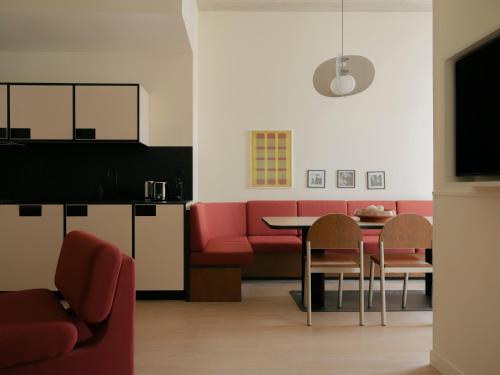 a living room with a red couch and a table at Edgar Suites - Église in Paris