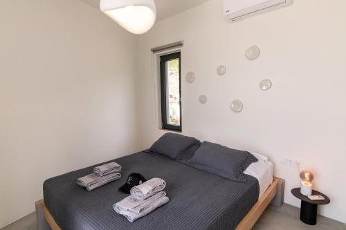 a bedroom with a bed with towels on it at Rockaine Suites Echoes in Tinos
