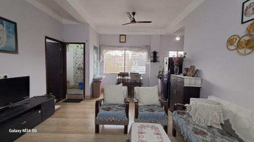 a living room with a couch and a tv at Vedic villa Apt in Siliguri