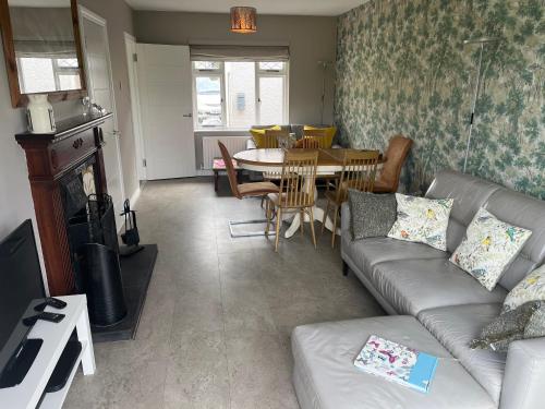 a living room with a couch and a table at Ballymacdoe Cottage Cushendall in Cushendall