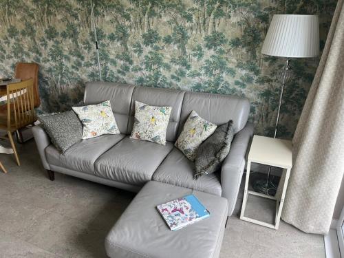 a gray couch with pillows in a living room at Ballymacdoe Cottage Cushendall in Cushendall