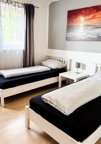 a bedroom with two beds and a table and a window at Haus 6-12P - 6Zi - Aurora Hamburg in Wenzendorf