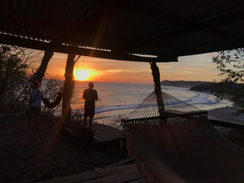 two people standing in a hammock watching the sunset at Casa Medusa in El Gigante