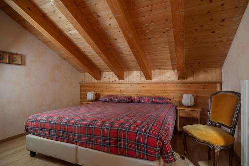 a bedroom with a bed and a chair in a room at Chalet Stelle Di Neve in Bormio