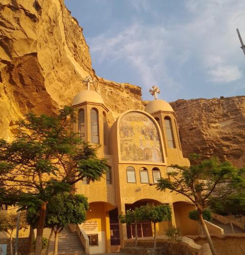 a yellow church in front of a mountain at Akh Pyramid Hostel in Cairo