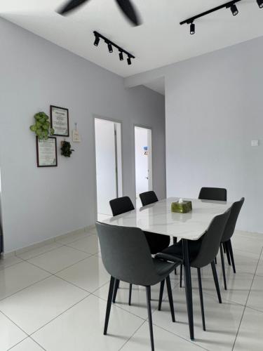 a white dining room with a white table and chairs at The Horizon - Ipoh' Rachel in Ipoh