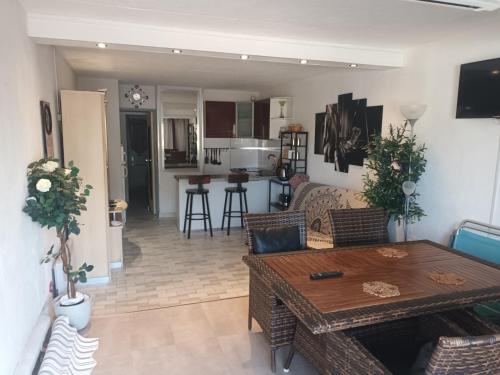 un salon avec une table et une cuisine dans l'établissement Village Naturiste, Cap d'Agde Port Nature 522, au Cap d'Agde
