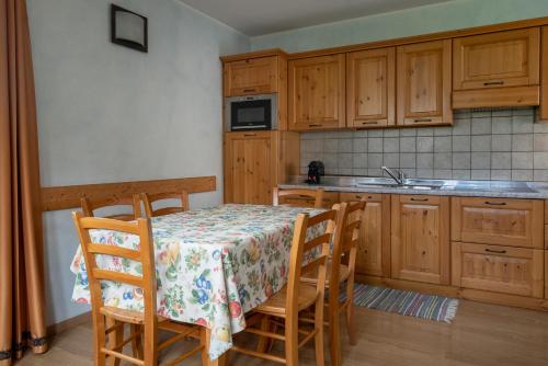 a kitchen with a table and chairs and a sink at Chalet Stelle Di Neve in Bormio
