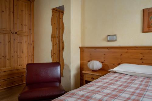 a bedroom with a bed and a chair in it at Chalet Stelle Di Neve in Bormio