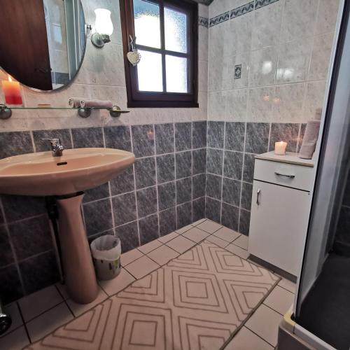 une salle de bain avec un lavabo et un miroir dans l'établissement Chez Nicole et Patrick, à Chouvigny