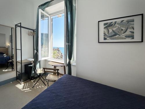 a bedroom with a bed and a desk and a window at Hotel Meublè Agavi in Monterosso al Mare