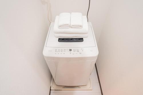 a washing machine with two towels on top of it at Shinjuku Terrace 226 BnB in Tokyo
