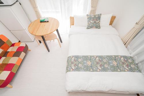 a small room with two beds and a table at Shinjuku Terrace 226 BnB in Tokyo