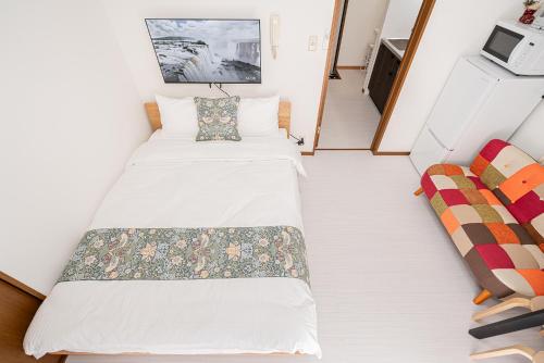 a small room with two beds and a couch at Shinjuku Terrace 226 BnB in Tokyo