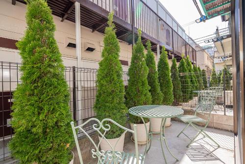 a patio with a table and chairs and trees at Shinjuku Terrace 226 BnB in Tokyo