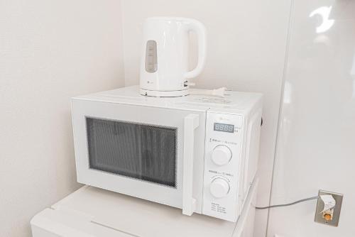 a white microwave with a blender on top of it at Shinjuku Terrace 226 BnB in Tokyo