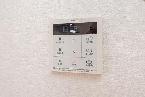 a lightswitch hanging on a wall with aktop at Shinjuku Terrace 226 BnB in Tokyo